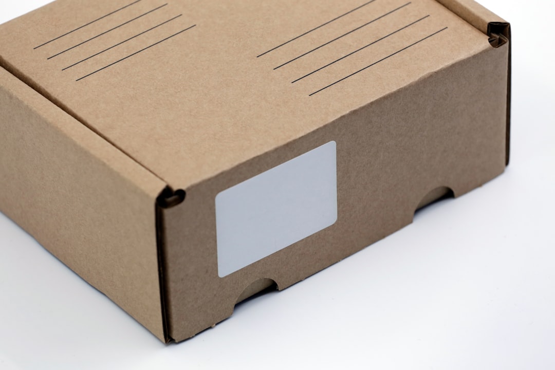 A blank cardboard delivery shipping box with a blank white address label